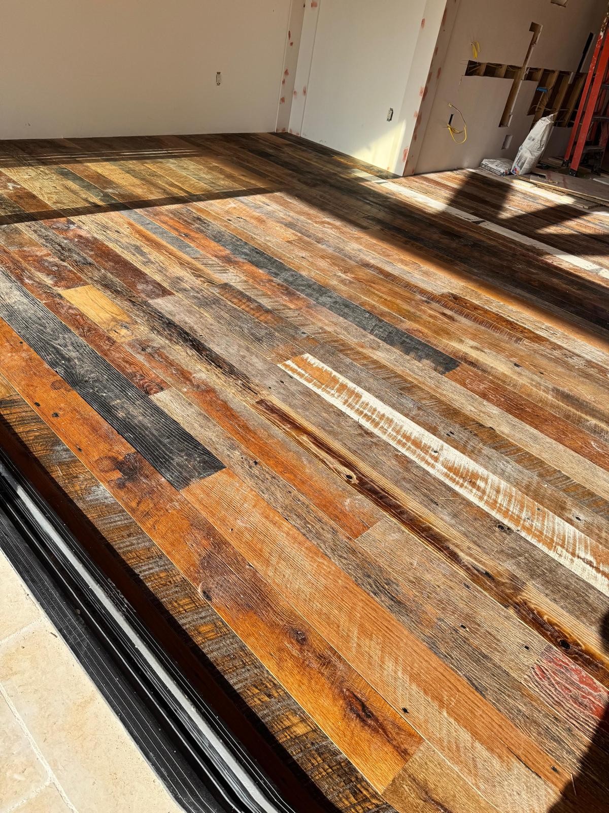 Reclaimed hardwood plank flooring across an open residential remodel
