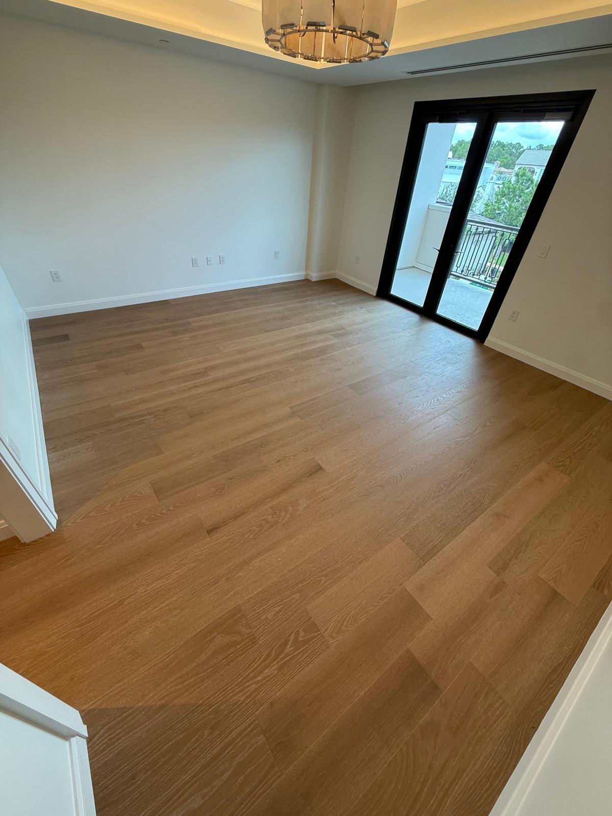 Light oak hardwood plank flooring in a high-end condo bedroom