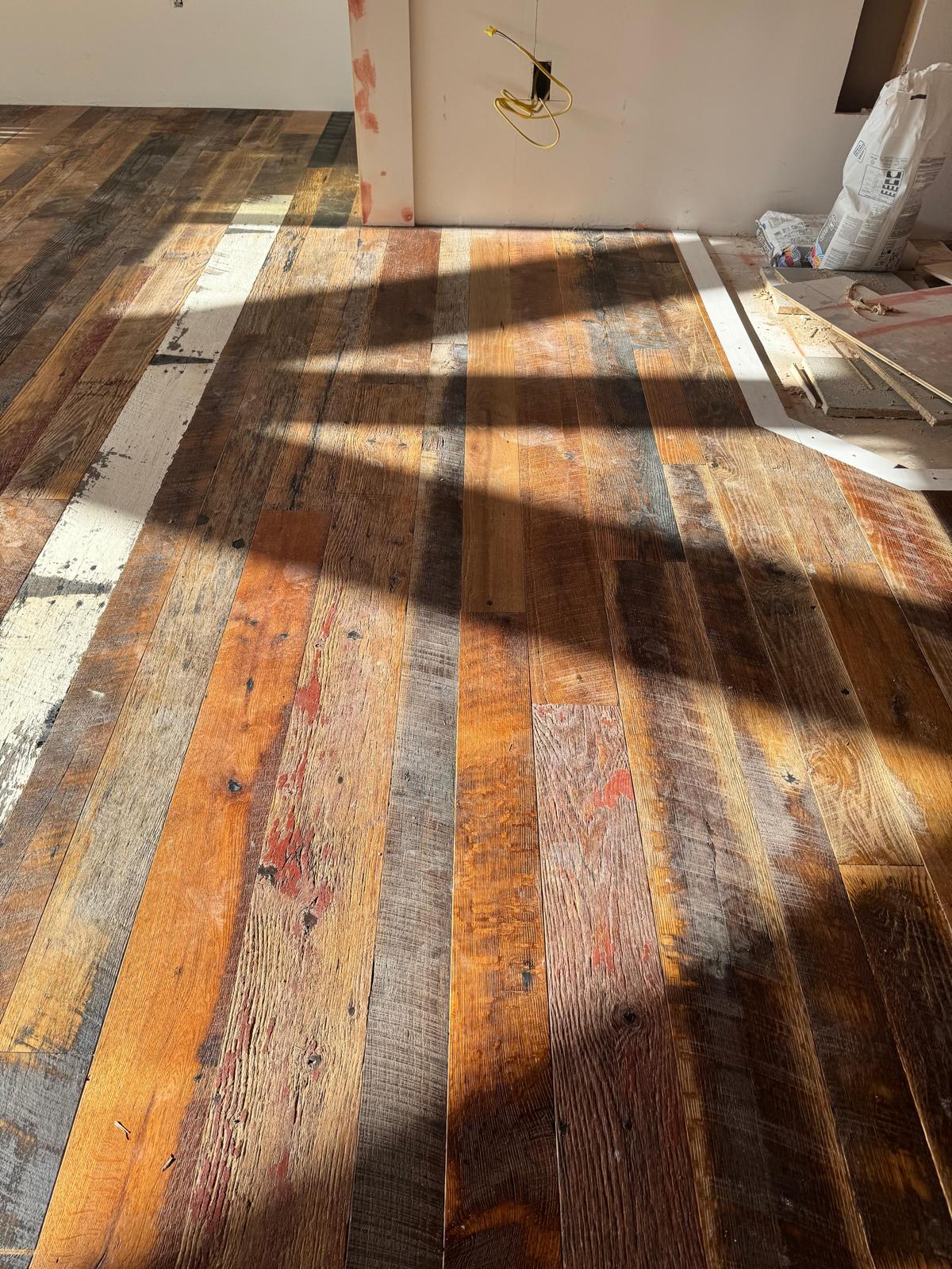 Sunlight detail on a reclaimed multi-tone hardwood plank floor