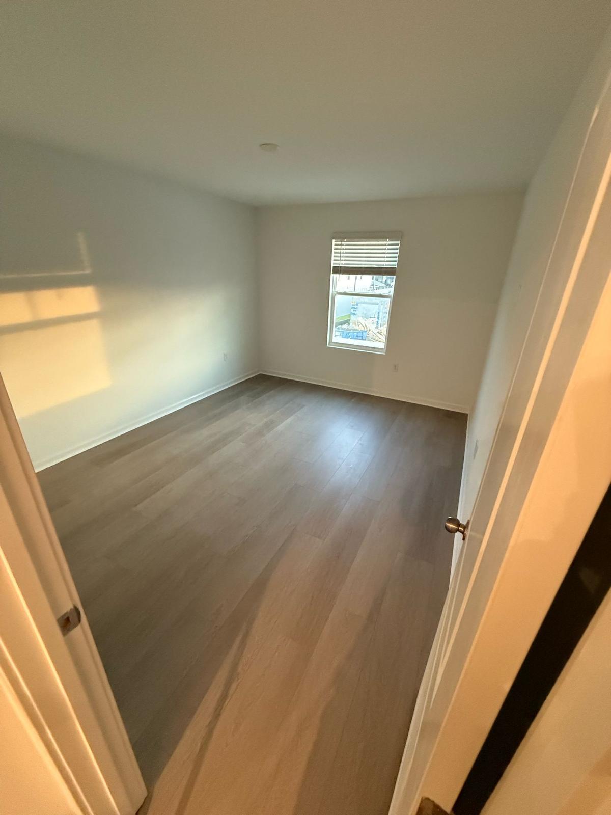 Grey-brown LVP plank flooring in a residential bedroom