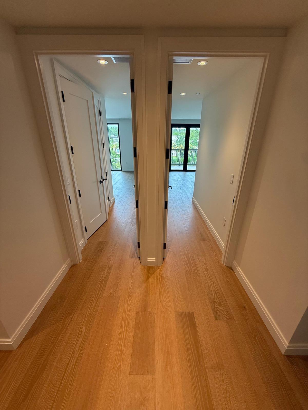 Red oak hardwood plank flooring in a luxury condo hallway