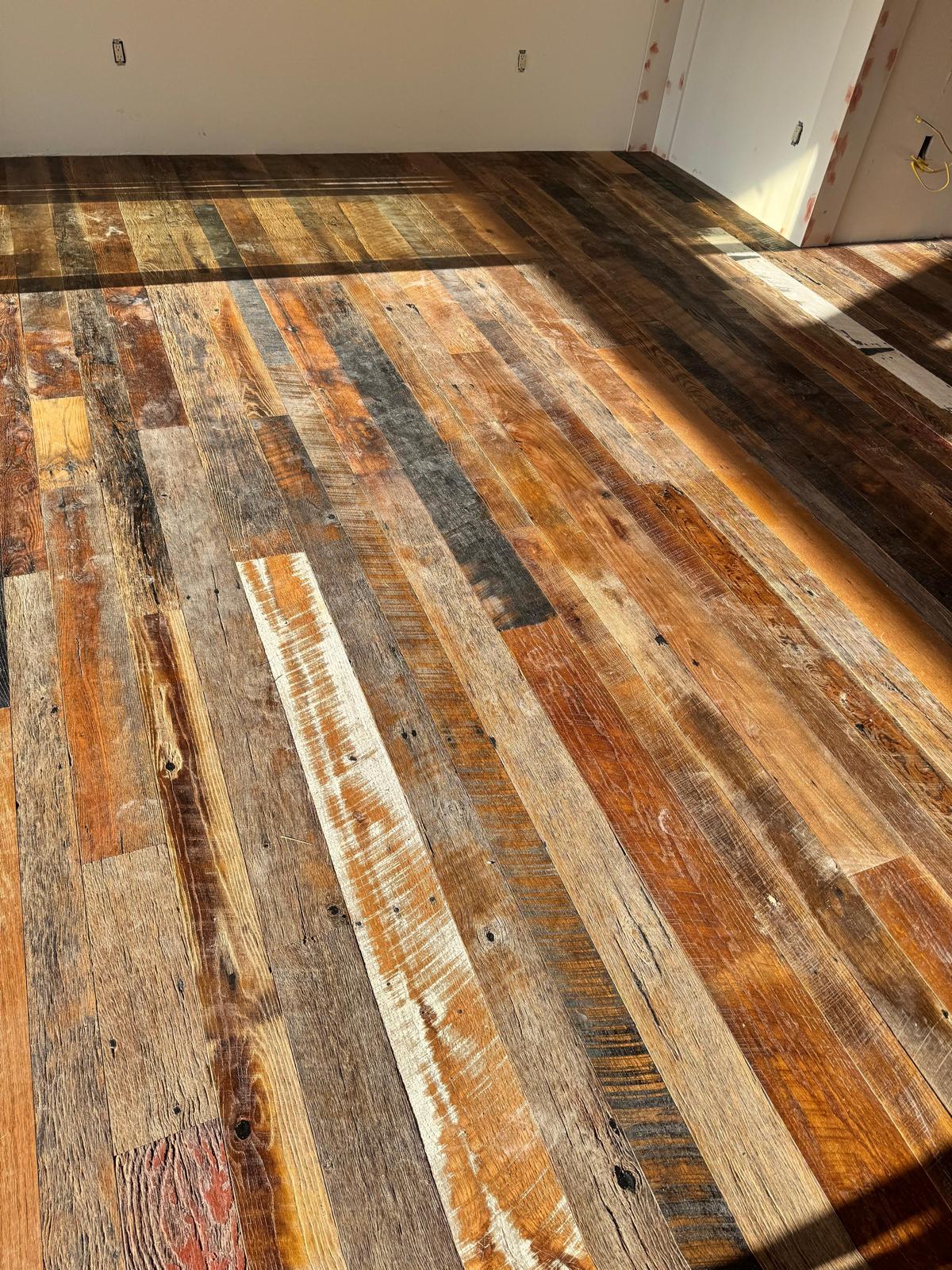 Reclaimed multi-tone hardwood plank installation in progress in a Central Florida home
